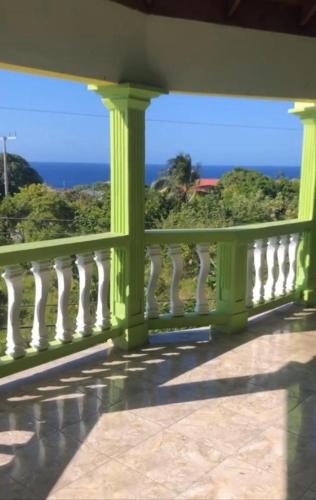 a green balcony with a view of the ocean at NesheLee Resorts in St Mary