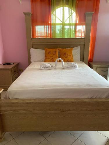 a bedroom with a large white bed with orange pillows at NesheLee Resorts in St Mary