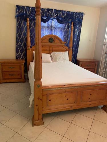 a bedroom with a wooden bed with a canopy at NesheLee Resorts in St Mary