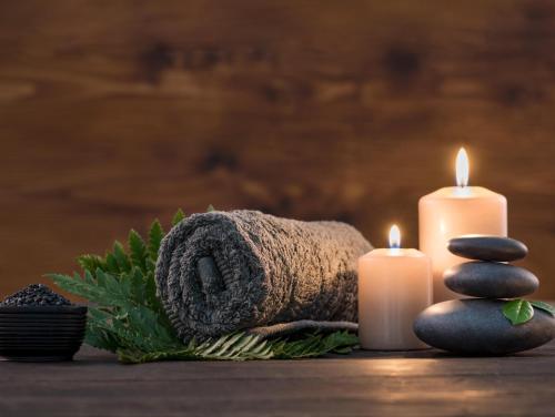 a pile of towels and candles on a table at Pich Kunthea Angkor Resort in Phumĭ Kruŏs