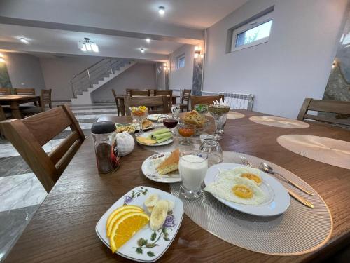 a wooden table with plates of breakfast food on it at Mountain View in Kochkor