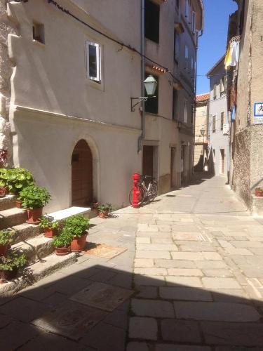 an alley with a red fire hydrant next to a building at Apartments Kremenic in Cres