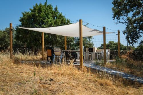 a tent with chairs and a table in a field at Hamlets Friends Rural House in Nuño Gómez