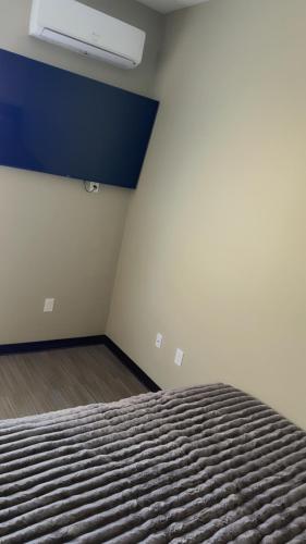 an empty room with a bed and a blue wall at Willow e-hotel in Mattoon