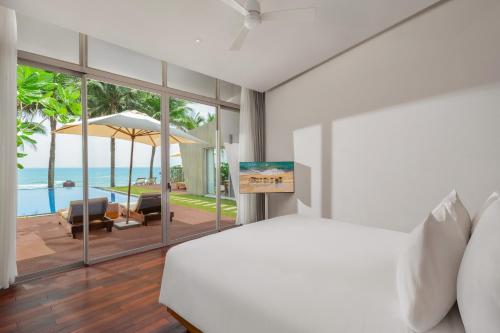 a bedroom with a bed and a view of the ocean at Naman Retreat in Da Nang