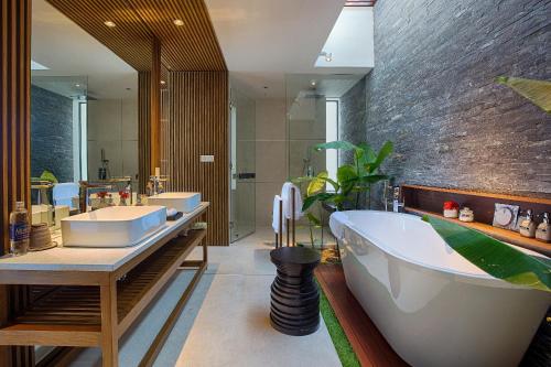 a bathroom with two sinks and a bath tub at Naman Retreat in Da Nang