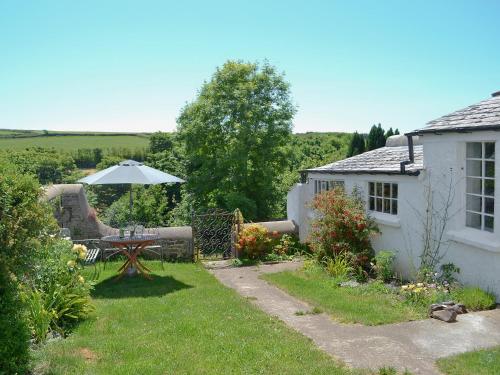 a small garden with a table and an umbrella at The Square in Hartland