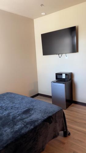a bedroom with a bed and a flat screen tv at Willow e-hotel in Mattoon