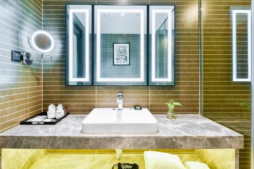 a bathroom with a sink and a mirror at Xana Hotelle Wuxi Railway Station Zhongshan Road in Wuxi