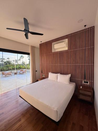 a bedroom with a bed and a ceiling fan at Julim Terra in Amed