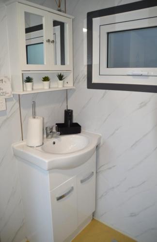 a white bathroom with a sink and a mirror at Gallery Walk Getaway in Mount Tamborine