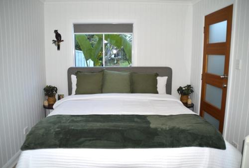 a bedroom with a large white bed with a window at Gallery Walk Getaway in Mount Tamborine