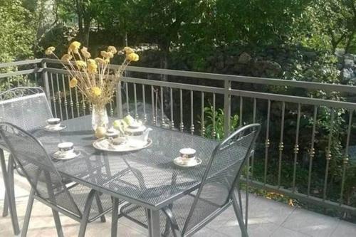 a table with chairs and a vase with flowers on it at Holiday house between the sea and lakes in Grubine