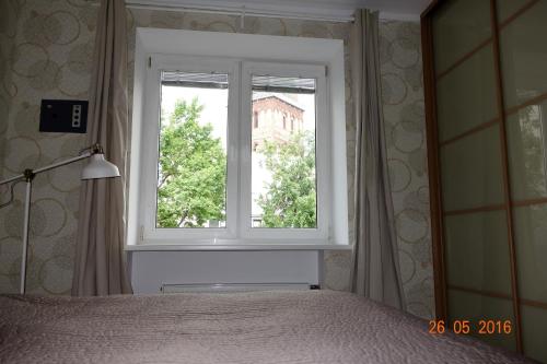 a bedroom with a window with a bed and a lamp at Riga Old Town River View with balcony in Rīga
