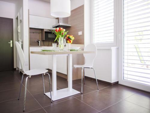 a white dining room table with white chairs and flowers at Villa Irene in Trenčianske Teplice