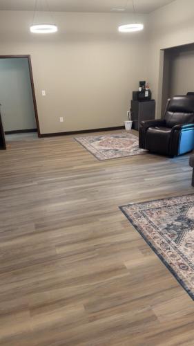a living room with a leather couch and wood floors at Willow e-hotel in Mattoon