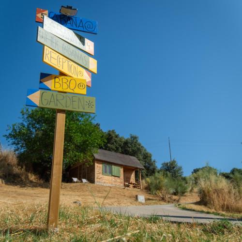 a street sign with many signs in front of a house at Hamlets Friends Rural House in Nuño Gómez