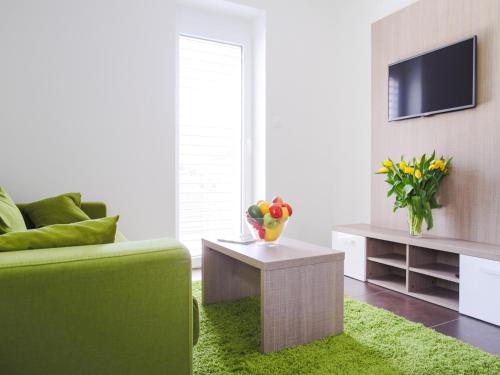 a living room with a green couch and a television at Villa Irene in Trenčianske Teplice