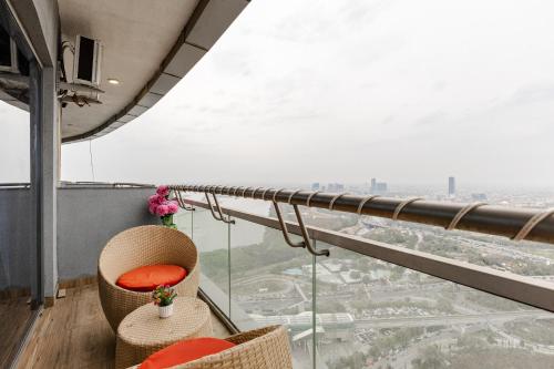 a balcony with two chairs and a view of a city at Cloud stays 36th floor in Noida