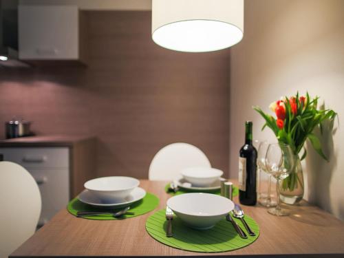 a dining room table with two bowls and a bottle of wine at Villa Irene in Trenčianske Teplice