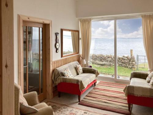 a living room with a view of the ocean at The Old School House in Lonbain