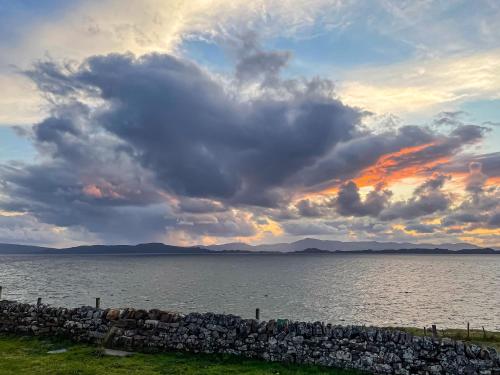 a cloudy sky over a large body of water at The Old School House in Lonbain
