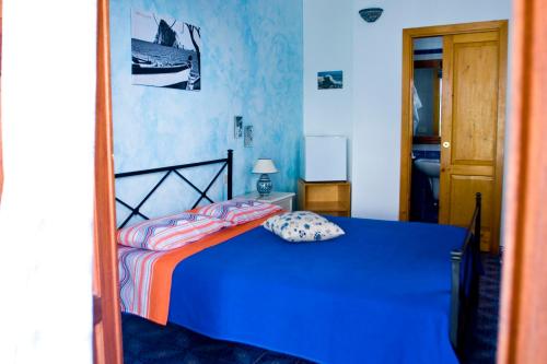 a blue bedroom with a bed in a room at La Sirena in Panarea