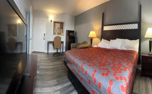 a hotel room with a bed and a desk at Blue Way Inn and Suites Roseville in Roseville