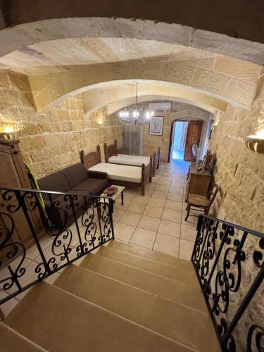 a view of a living room with a stone wall at Rustic Farmhouse with Pool in Xewkija