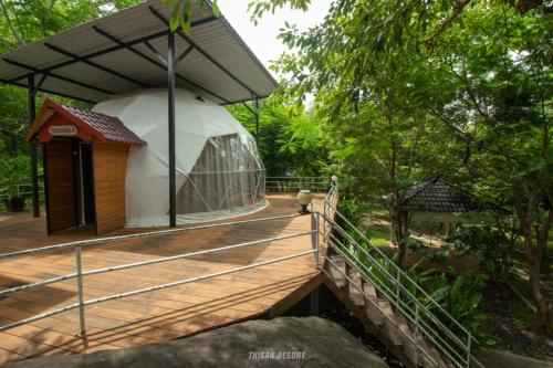 a large tent with a wooden deck in a forest at Thisak Resort Cheung phnom kulen in Siem Reap