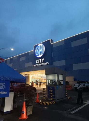 a man standing in front of a car dealership at Brittany Bliss Staycations at SMDC HOPE RESIDENCES in Trece Martires