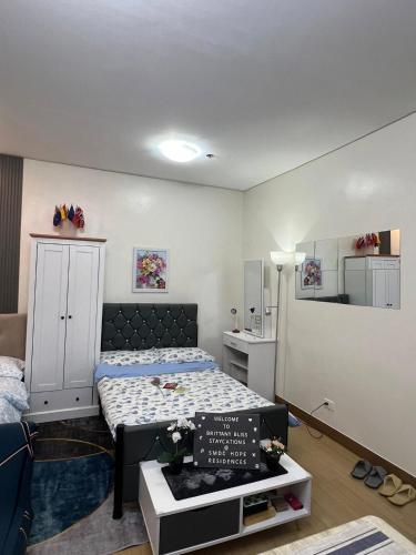 a small bedroom with a bed and a cabinet at Brittany Bliss Staycations at SMDC HOPE RESIDENCES in Trece Martires