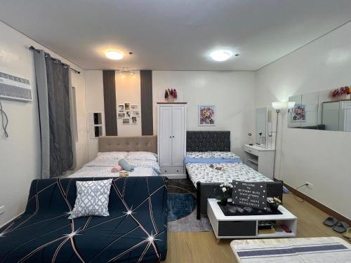 a small room with two beds and a table at Brittany Bliss Staycations at SMDC HOPE RESIDENCES in Trece Martires