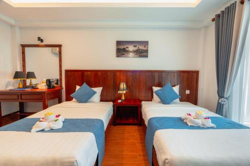 a hotel room with two beds with ducks on them at Pich Kunthea Angkor Resort in Phumĭ Kruŏs