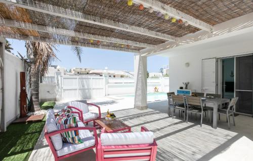 a patio with chairs and a table and a dining room at Residenza Flamingo in Marzamemi