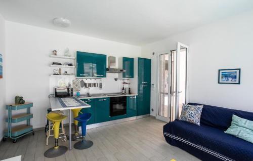 a living room with a blue couch and a kitchen at Residenza Flamingo in Marzamemi