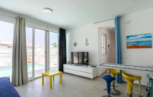 a living room with a television and yellow chairs at Residenza Flamingo in Marzamemi