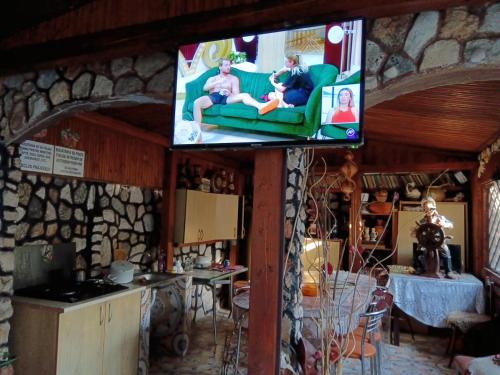 Un televisor con dos personas sentadas en un sofá en una habitación. en Tarra Garsoniera10, en Mangalia