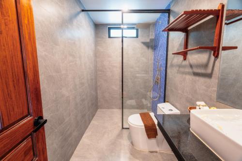 a bathroom with a shower and a toilet and a sink at Pich Kunthea Angkor Resort in Phumĭ Kruŏs