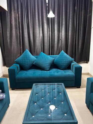 a living room with a blue couch and a table at 3 Bhk Air Deck luxury apartment in Patna