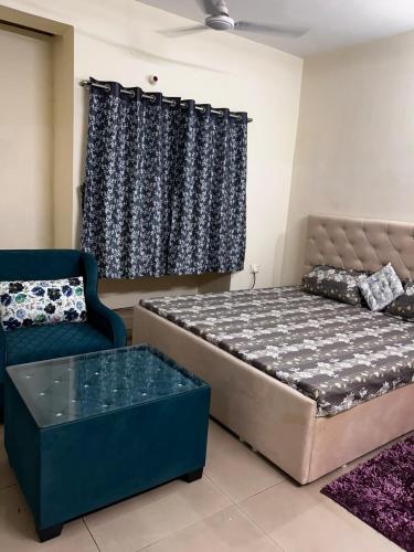 a bedroom with a bed and a couch and a window at 3 Bhk Air Deck luxury apartment in Patna