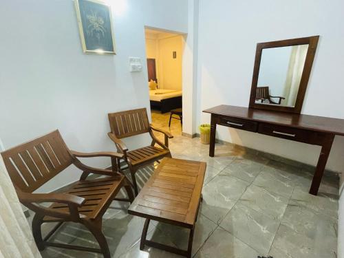 a room with two chairs and a desk and a mirror at Sholay Villa in Galle