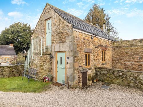 an old stone house with a stone wall at Tawny Owl Barn in Barlow