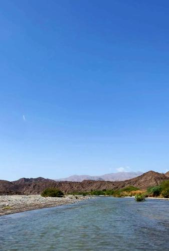 a river in the desert with mountains in the background at مسقط شقة 3 غرف نوم in Al Khawḑ