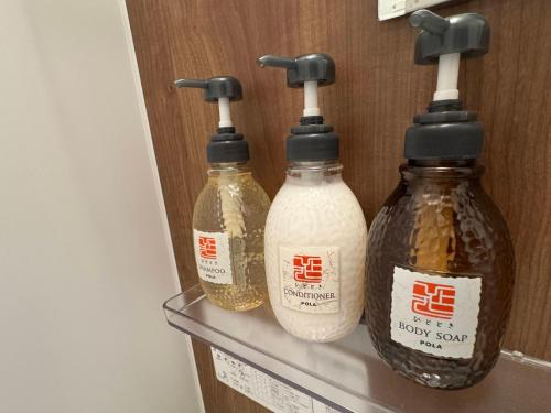 three bottles of honey sitting on a shelf at LikeINN札幌スイーズS4 in Sapporo