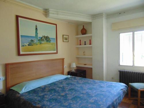 a bedroom with a bed and a picture on the wall at Casa para grupos grandes en Madrid in Miraflores de la Sierra