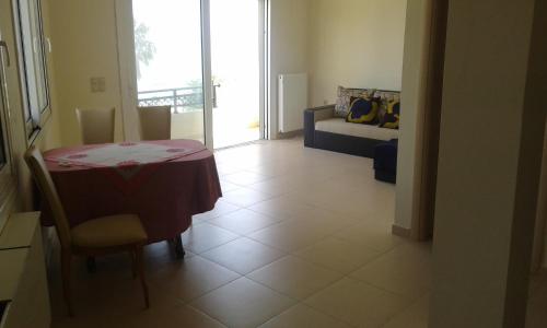 a dining room with a table and a couch at Rossi apartment in Hersonissos