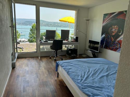 チューリッヒにあるZürichsee, Privatzimmer atemberaubender Aussichtのベッドルーム1室(ベッド1台、窓のあるデスク付)