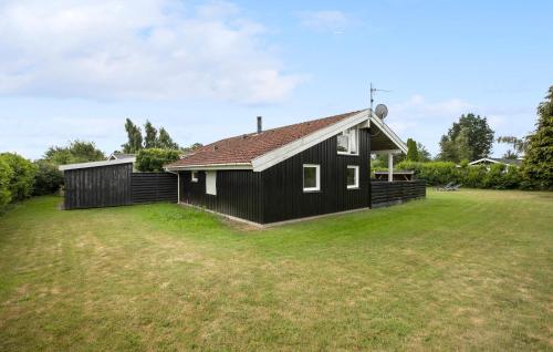 a black and white house with a large yard at Holiday Home Birkemose Ds Dnmk in Skovby