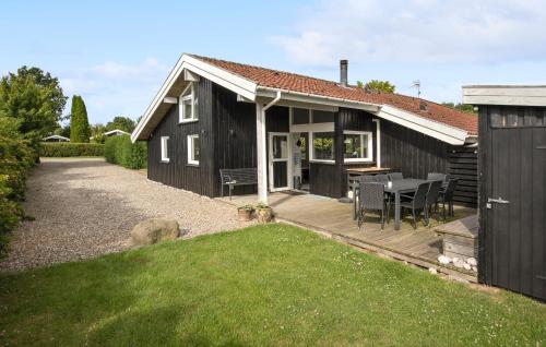 a black house with a wooden deck with a table at Holiday Home Birkemose Ds Dnmk in Skovby